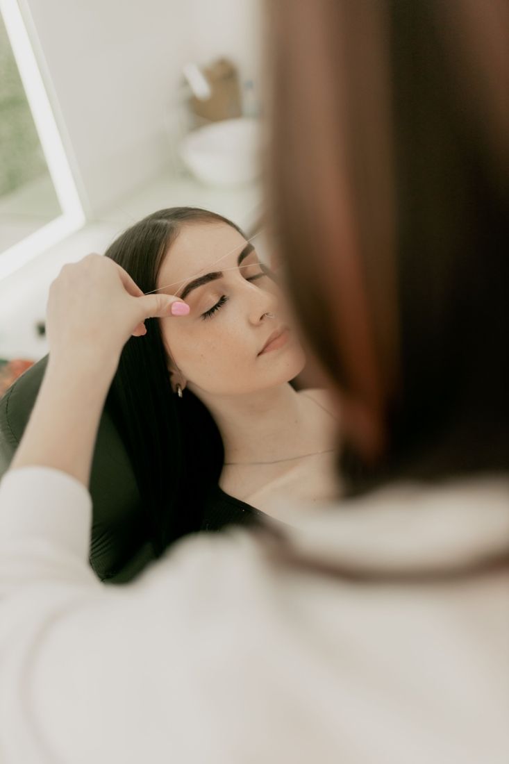 A relaxed client during a brow appointment in a bright studio